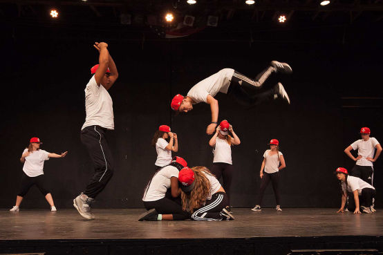A camper doing a flip during a hip-hop performance